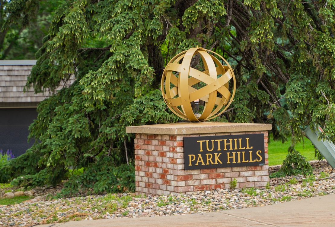 A photograph of the Tuthill Park entrance sign on Cliff Avenue that reads Tuthill Park Hills